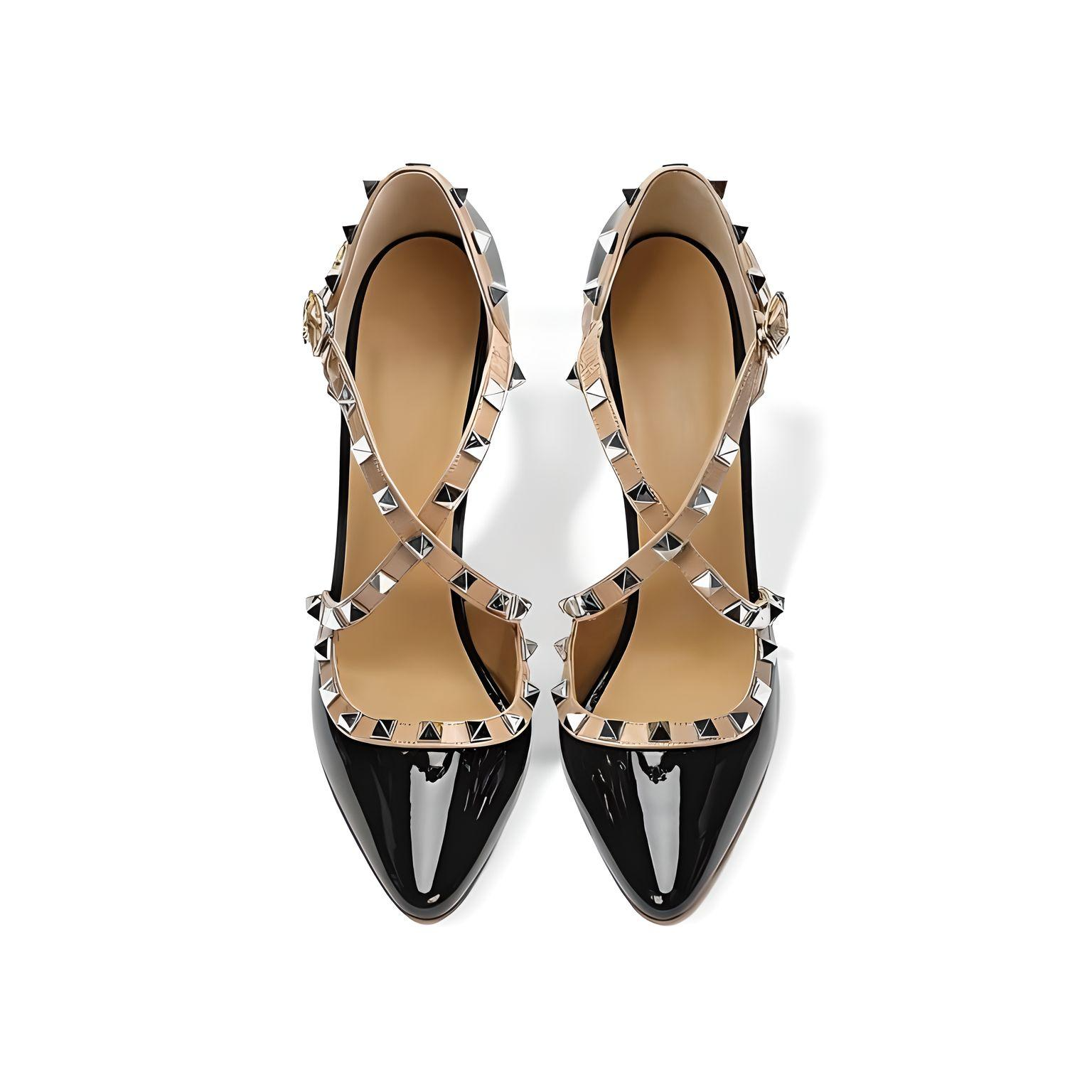Top-down view of black patent stiletto pumps with pointed toe and stud accents
