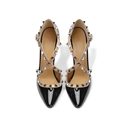Top-down view of black patent stiletto pumps with pointed toe and stud accents
